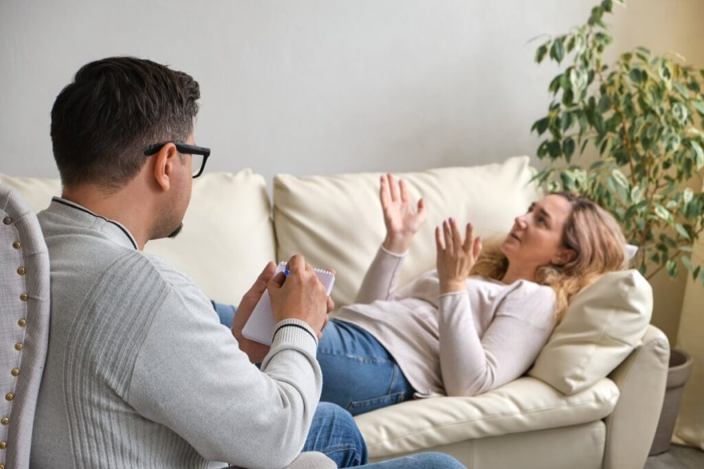 Osoba leżąca na kanapie podczas sesji terapeutycznej odkrywa korzyści psychoterapii.