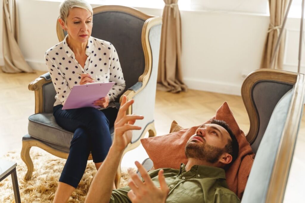 Terapeuta słucha pacjenta i rozważa wprowadzenie leki w terapii.