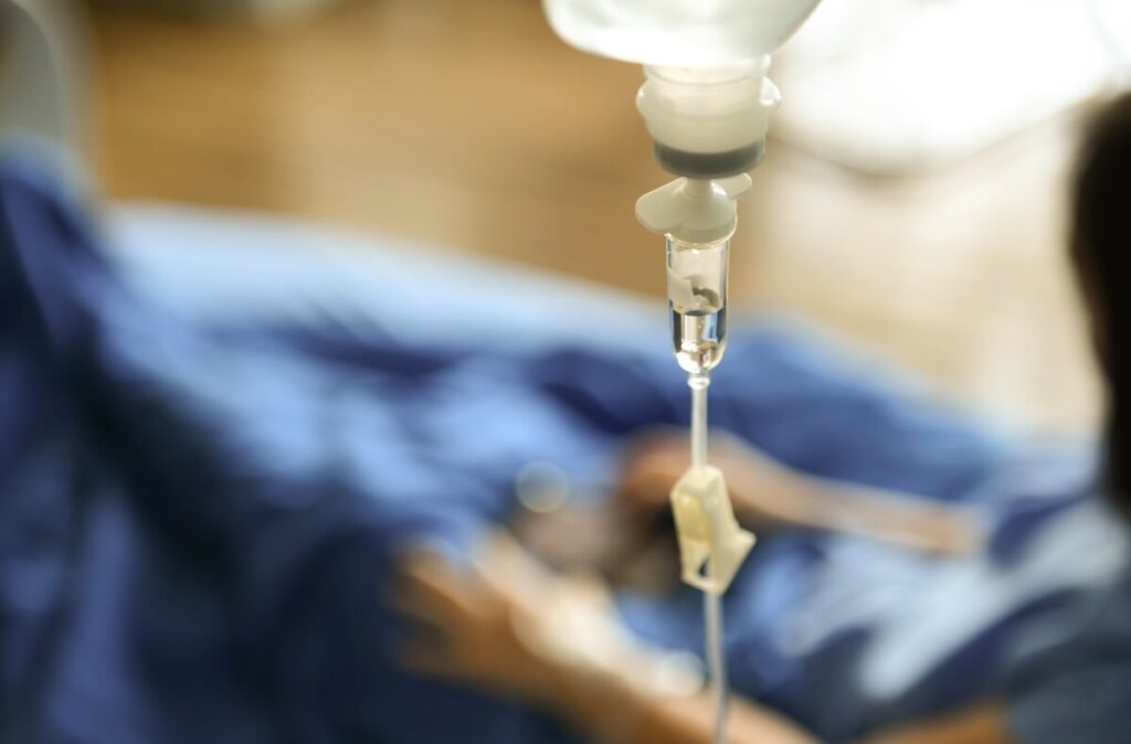 Osoba w szpitalu otrzymuje kroplówkę, co może być częścią leczenia chorób autoimmunologicznych.