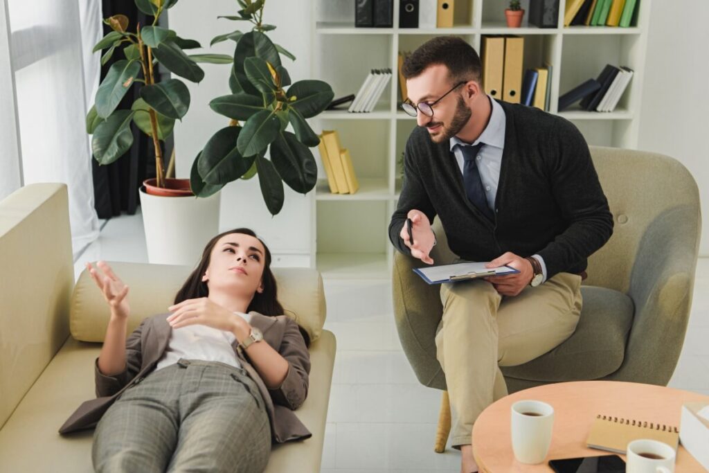 Terapeuta rozmawia z pacjentką, stosując techniki terapeutyczne.